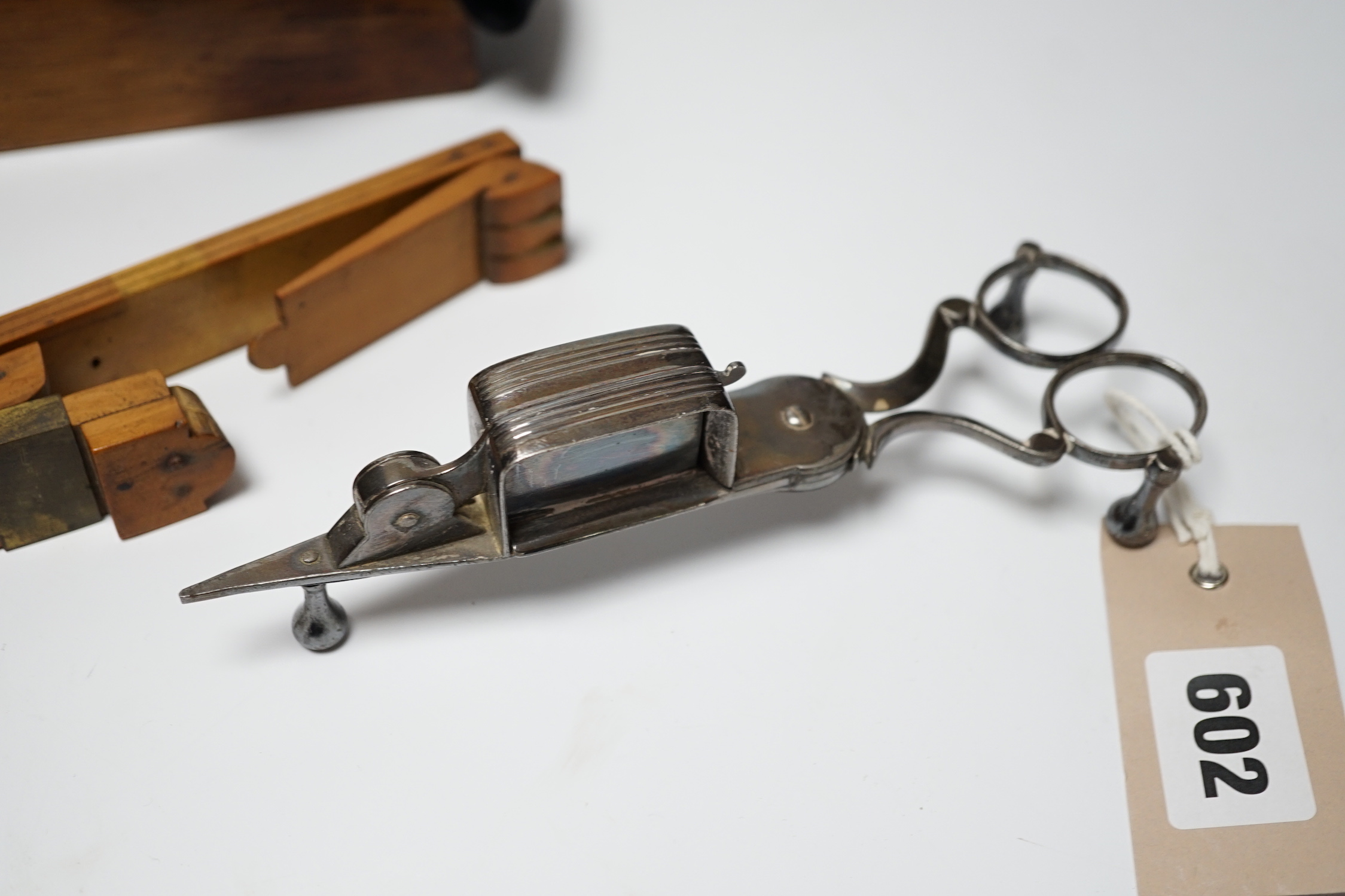 A glove box containing a boxwood foot-measure, two candle snuffers, a silver teaspoon etc